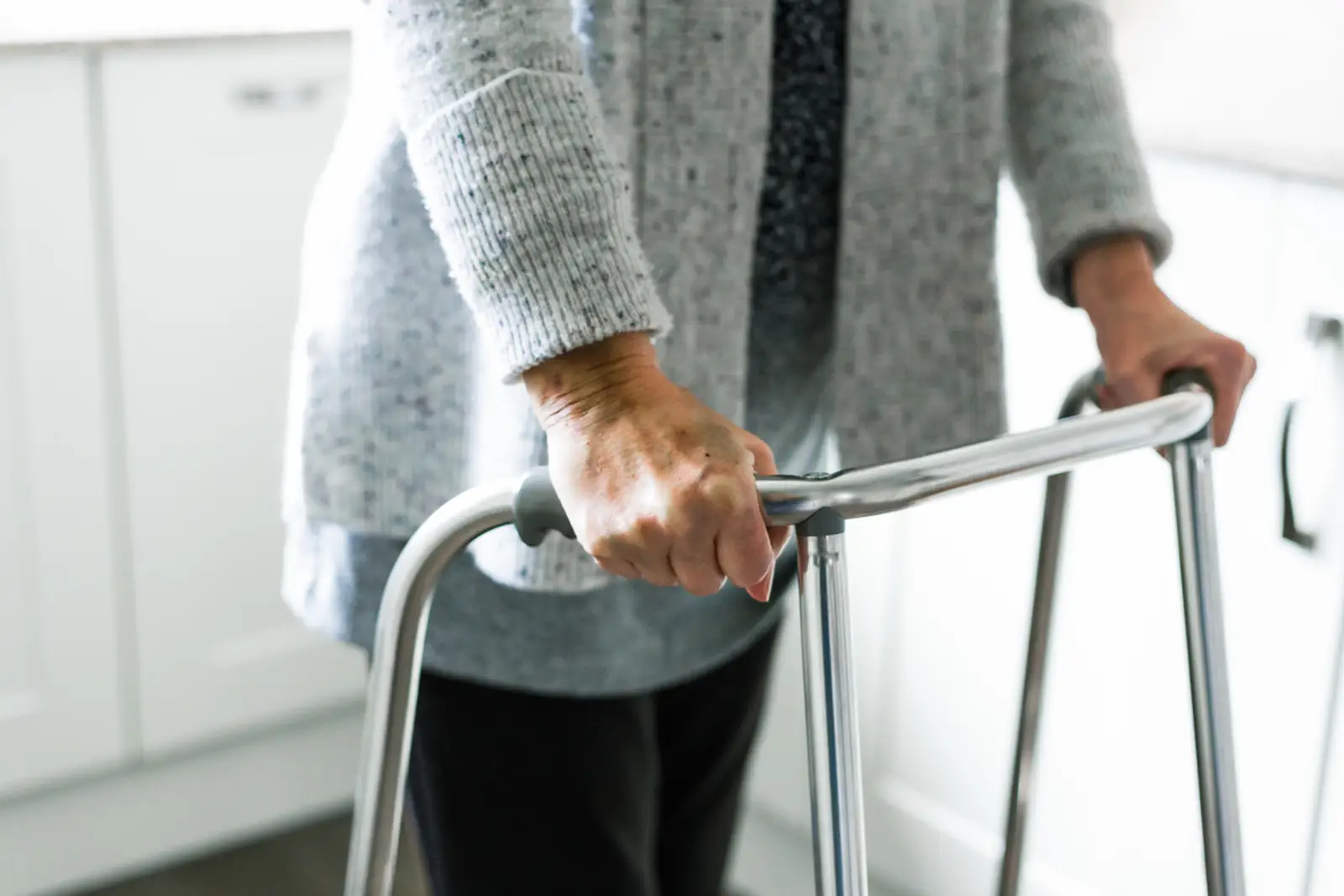 Senior walking carefully at home with a walker after a fall